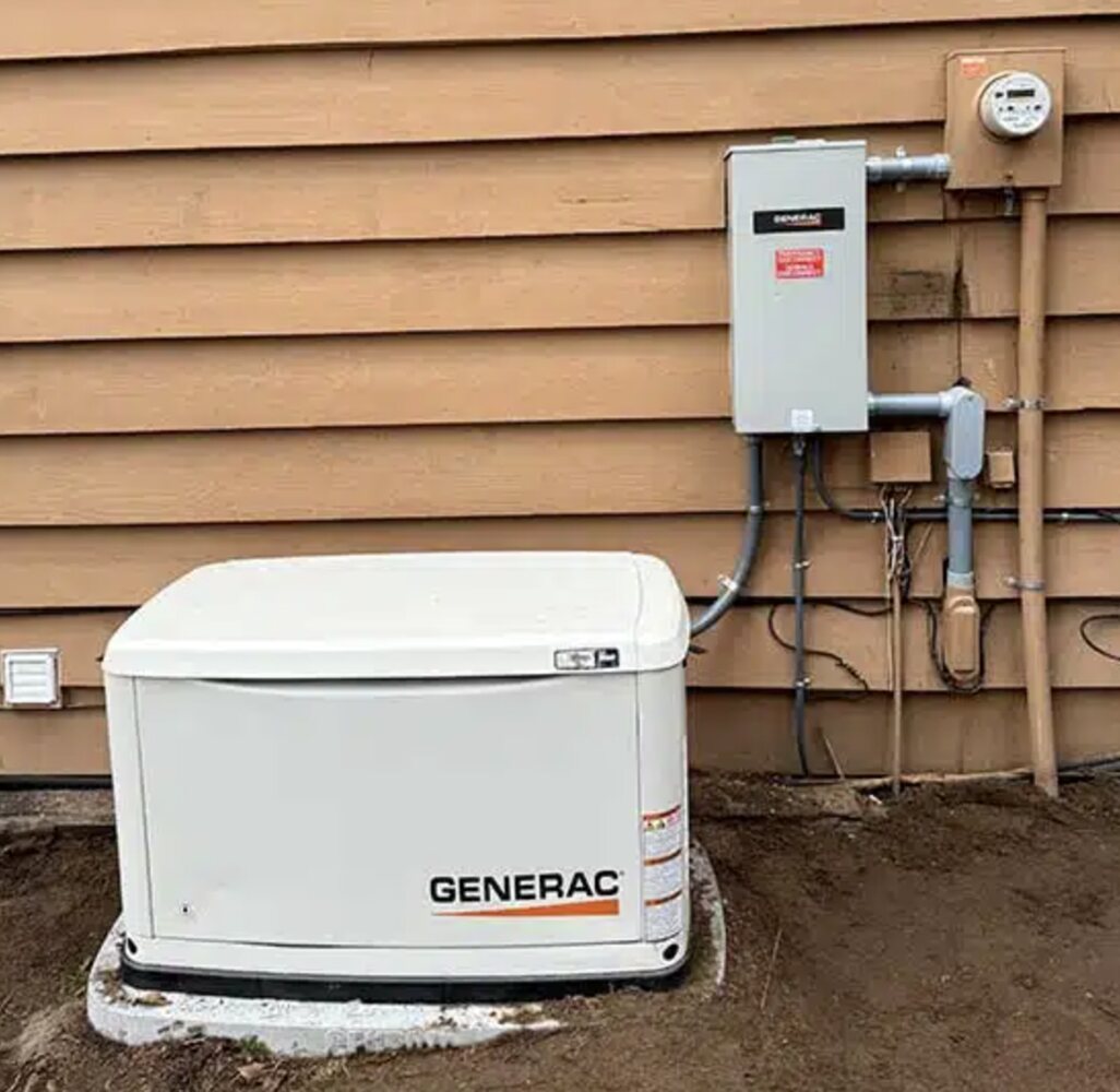 Generac standby generator on a concrete pad with the transfer switch mounted on the wall above, Clark County WA