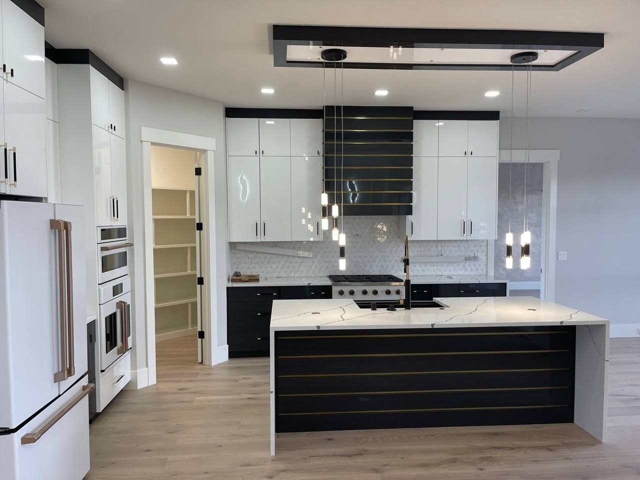 Linear pendants over a kitchen island with recessed tray lighting, Clark County WA